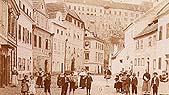 Die Široká-Gasse (Breite Gasse) in Český Krumlov, im Vordergrund die Einwohner der Stadt, im Hintergrund das Schloss, ein historisches Foto 