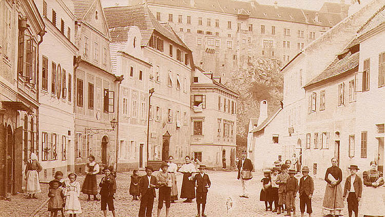 Široká Street in Český Krumlov, in the foreground residents of the town, in the background is Český Krumlov Castle, historical photo