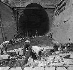 Vodní elektrárna Lipno, odpadní tunel, dláždění dna vyústění tunelu, v pozadí portál, rok 1956, historické foto  