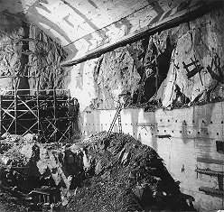 Wasserkraftwerk Lipno, Lipno I - Kraftwerk, Ausbrechen des Kerns vom Maschinenraum. Rechts ausbetoniertes Portal der Abfälle, hinten die Stirnwand mit einer Störungszone. März 1957, ein historisches Foto 