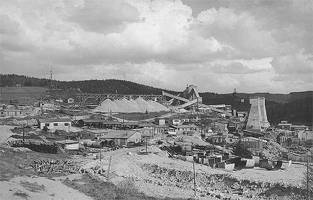 Wasserkraftwerk Lipno, Einrichtung der Baustelle in Lipno, im Hintergrund die Deponie von zerkleinerten Steinen. Im Vordergrund der Abladeplatz für Panzer der Druckschächte, rechts Fördertürme und Kabelkran 5 t. Mai 1957, ein historisches Foto 