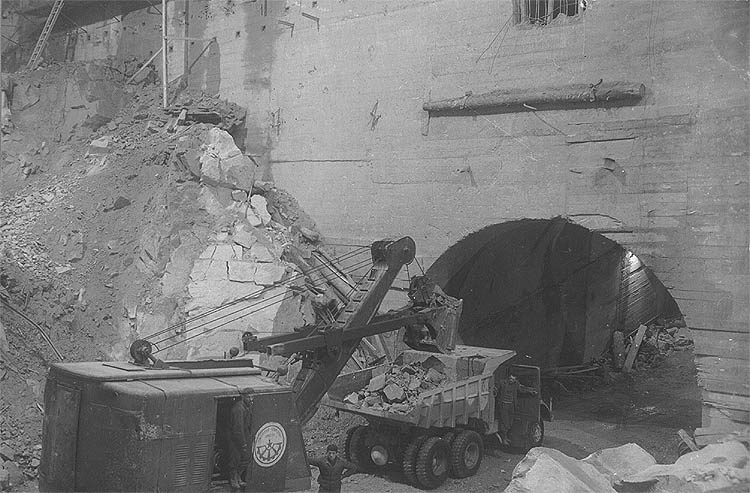 Vodní elektrárna Lipno, Lipno I - Elektrárna, plný výlom jádra strojovny, nakládání rubaniny a její odvoz auty odpadním tunelem, září 1957, historické foto