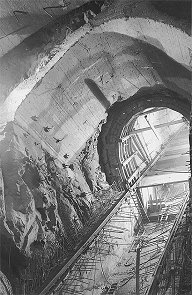 Wasserkraftwerk Lipno, Schräger Tunnel, 15. Band der Ummauerung vor der Betonierung des oberen Teils. Der untere Teil wurde ausbetoniert und zur Durchführung der Isolation der inneren Ummauerung vorbereitet. Oben Hilfsgewölbe über dem 15. Band und ein Teil des Hauptgewölbes über dem Maschinenraum. Oktober 1957, ein historisches Foto 