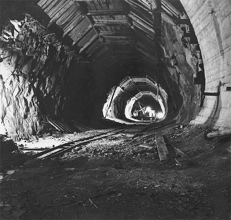 Vodní elektrárna Lipno, odpadní tunel, doprava bagru D 500 do podzemní strojovny, na stropě tunelu, historické foto