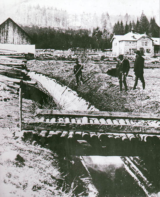 Schwarzenberský plavební kanál s dělníky při plavení dřeva, historické foto